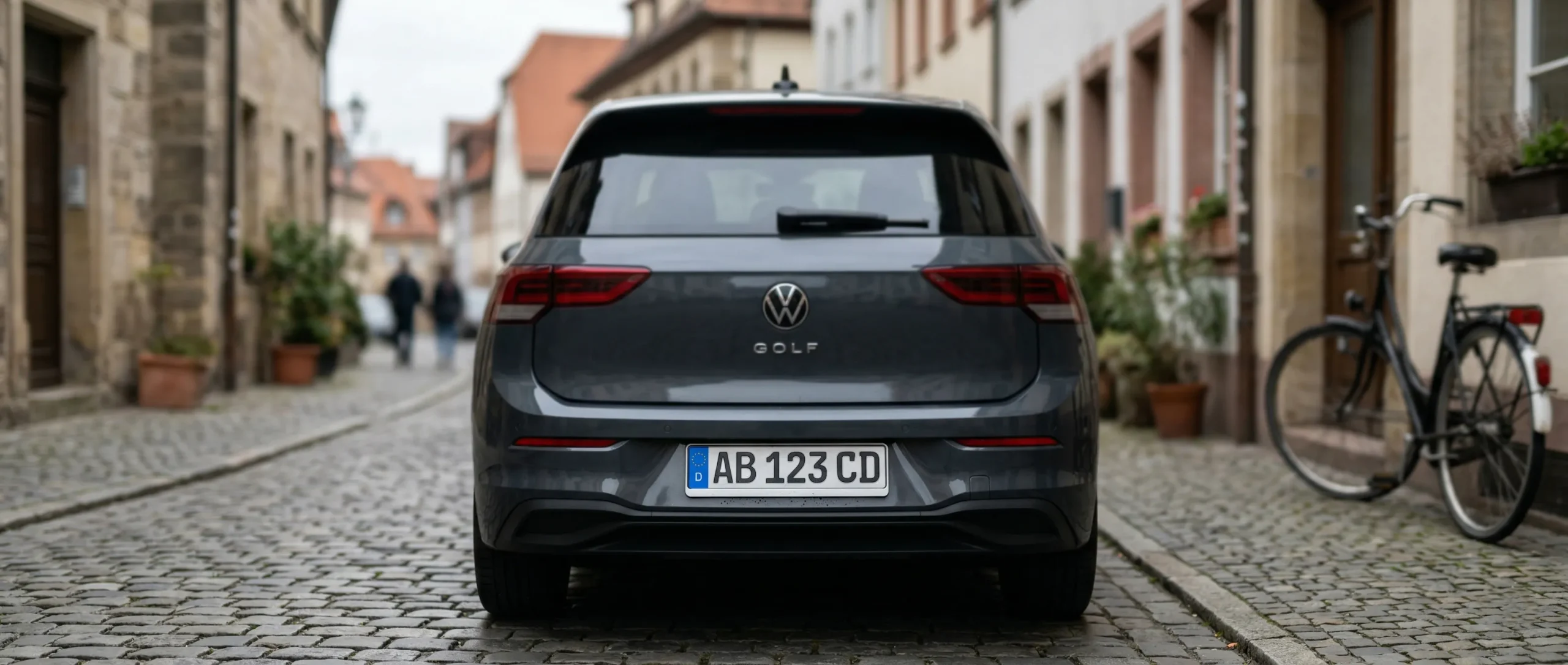 Europäisches Kennzeichen am Heck eines VW Golf auf Kopfsteinpflaster
